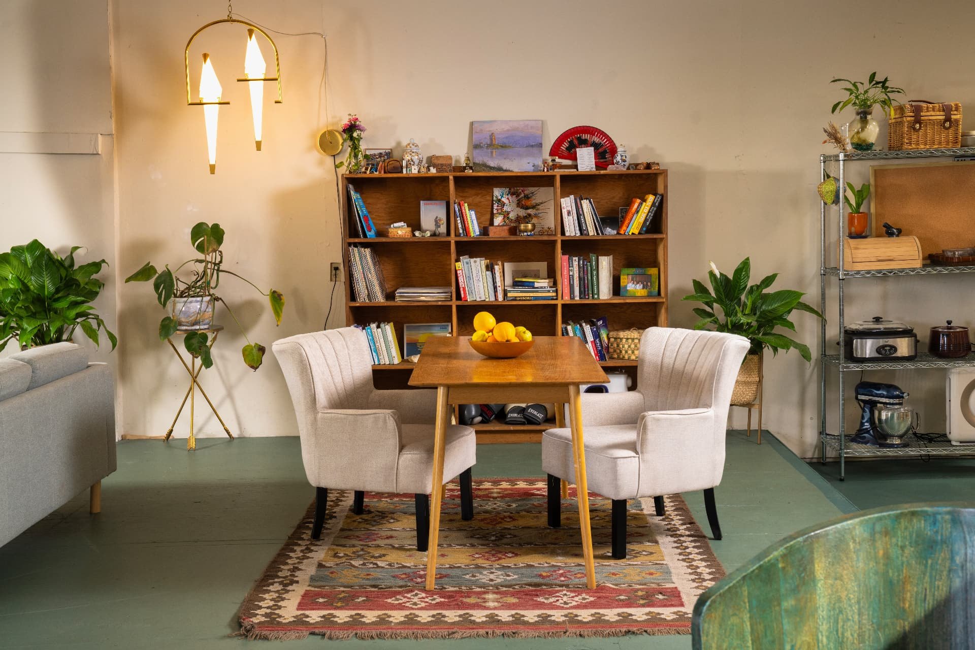 The quiet room: a rainbow of window light across a plaster wall above rugs, books and armchairs